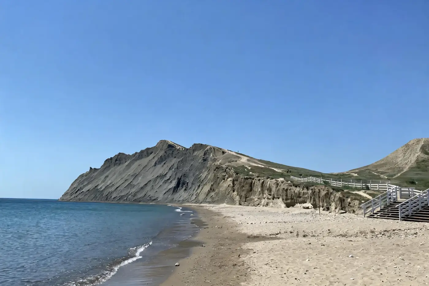 Пляж Тихой бухты — песок, бирюзовое море и скалистый мыс